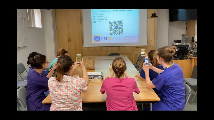 Resident doctors at Frimley Health NHS Foundation Trust scanning a CATQR code from a lecture theatre screen.