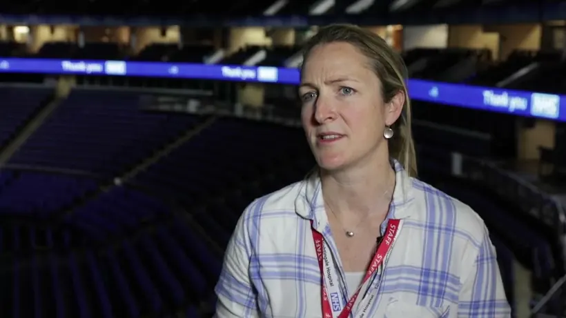 A member of staff at NHS Nightingale Hospital London speaking to camera from the main ward.